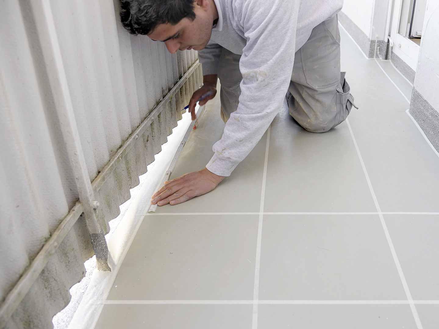 Aufkleben von Kreppband auf Verlaufmörtel für die spätere Optik der Fugen.