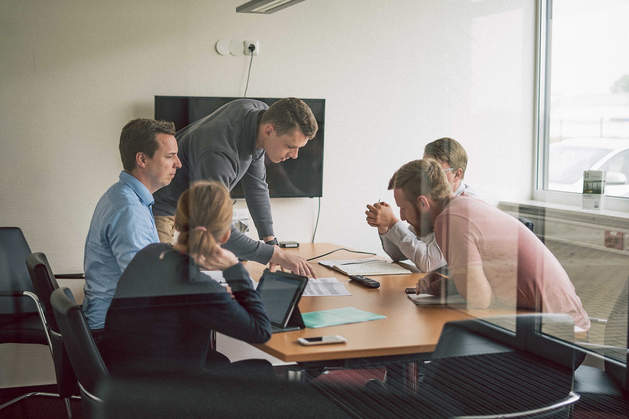 Besprechungssituation mit fünf Arbeitnehmern.